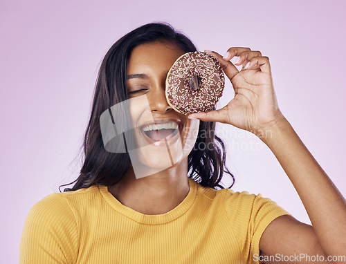 Image of Donut, laughing and cover with woman in studio for diet, snack and happiness. Sugar, food and smile with female hiding and isolated on pink background for nutrition, playful and craving mockup