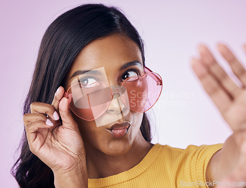 Image of Selfie, heart and sunglasses by indian woman in studio emoji, cool and fun on purple background. Glasses, trendy and female gen z fashion influencer posing for profile picture, photo or blog post