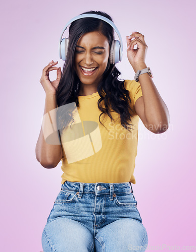 Image of Music, headphones and excited Indian woman dance on pink background listening to track, audio and radio. Relax, happy and isolated girl streaming song for dancing, chilling and happiness in studio