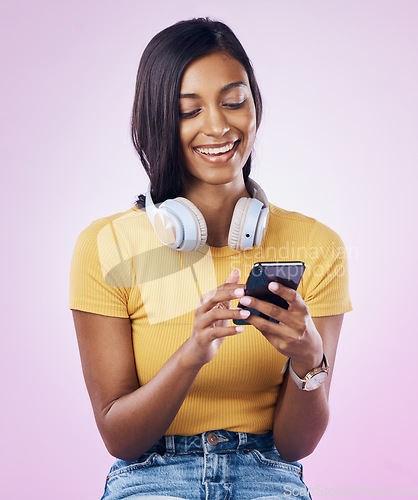 Image of Music, phone and Indian woman typing on pink background for social media, website and chatting. Relax, happy and isolated girl streaming audio, radio and track on smartphone for message on mobile app