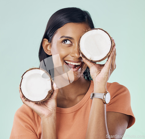 Image of Beauty, face and happy woman with studio coconut for natural skincare, organic cosmetics or eco friendly makeup. Vitamins, health benefits and excited female with fruit product on green background