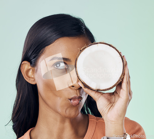 Image of Beauty, face or wellness woman with coconut for natural skincare glow, organic cosmetics or eco friendly makeup. Pucker, fruit nutrition benefits or person with clean healthy food on green background