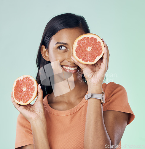 Image of Studio beauty, face and happy woman with grapefruit for natural skincare, health and wellness routine. Fruit detox, vitamin c benefits and nutritionist person with citrus product on green background