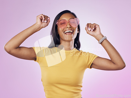 Image of Dance, sunglasses and happy woman excited, cool and confident isolated in a pink studio background with joy. Singing, music and young gen z female dancing celebration of a party energy with glasses