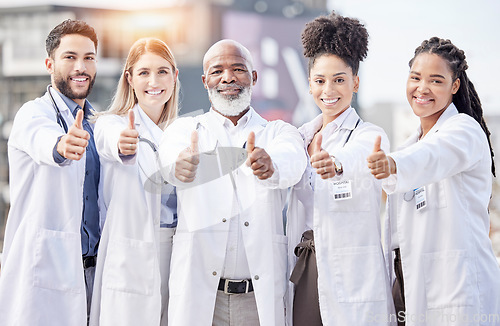 Image of Portrait, collaboration and thumbs up with a team of doctors standing outside of a hospital together. Teamwork, thank you or motivation with a team of professional healthcare workers feeling positive