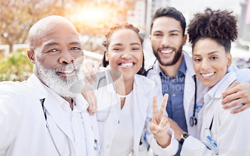 Image of Selfie, peace and collaboration with a team of doctors posing outdoor together while working at a hospital. Profile picture, healthcare and medical with a group of friends taking a photograph outside