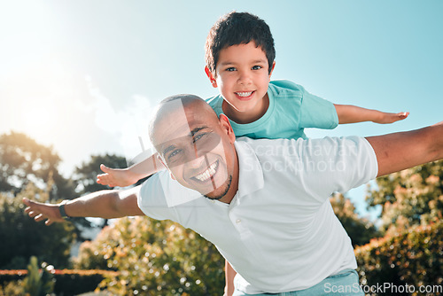 Image of Portrait, piggyback and a son flying on the back of his father outdoor in the garden while bonding together. Family, children or love and a boy playing with his dad in the backyard of their home