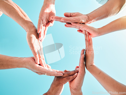 Image of Hands circle, synergy and below with sky, group and family with support, motivation or love. People, men and women with hand together for solidarity, bonding or outdoor with vacation, summer and help