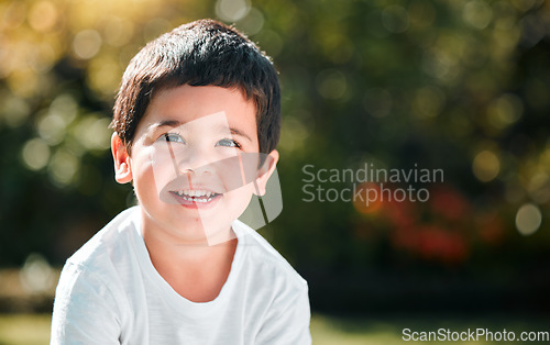 Image of Children, thinking and mockup with a boy in a park or garden, alone outdoor during a summer day. Kids, idea and smile with a happy male child outside in nature for freedom on a blurred background