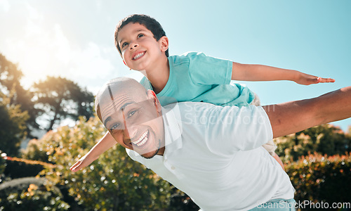 Image of Portrait, piggyback and a boy flying on the back of his father outdoor in the garden while bonding together. Family, children or love and a son playing with his dad in the backyard of their home