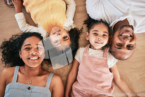 Image of Portrait, above and happy family on a floor, smile and bonding in a living room together. Top view, love and face of children with parents, relax and cheerful while having fun, lying and chilling