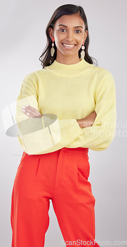 Image of Fashion, portrait and woman model in studio with a stylish, trendy and classy elegant outfit. Smile, style and young Indian female posing with crossed arms for confidence isolated by gray background.