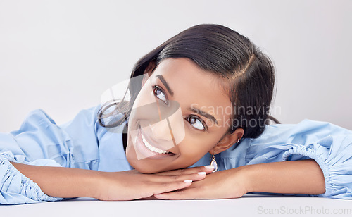 Image of Woman, studio and headshot for daydream, thinking and lying with motivation, vision or hope for future. Happy student, girl and relax with mindset for goals, opportunity or career by white background