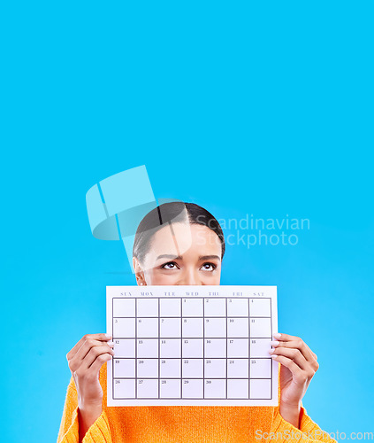 Image of Calendar, thinking and woman on blue background with paper for schedule, planning and agenda in studio. Time management, strategy and eyes of girl with month poster for date, weekly planner and event