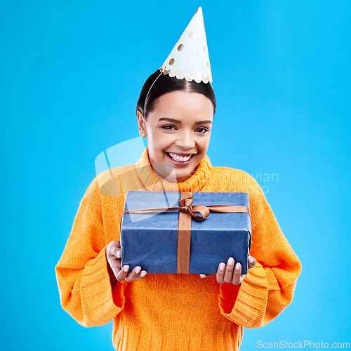 Image of Woman, portrait smile and gift in studio for birthday present, event or celebration against a blue background. Happy female smiling and holding gifts or box for party, surprise or giving on mockup