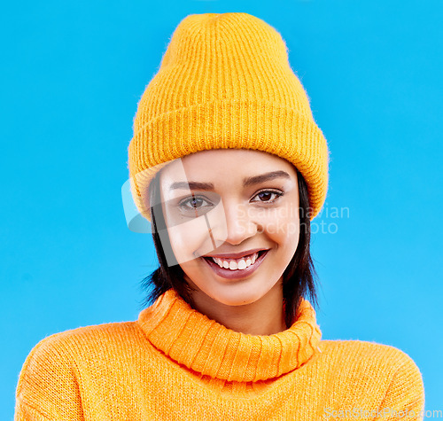Image of Portrait of happy woman in winter fashion with beanie, jersey and isolated on blue background. Style, happiness and gen z girl in studio backdrop with smile on face and warm clothing for cold weather