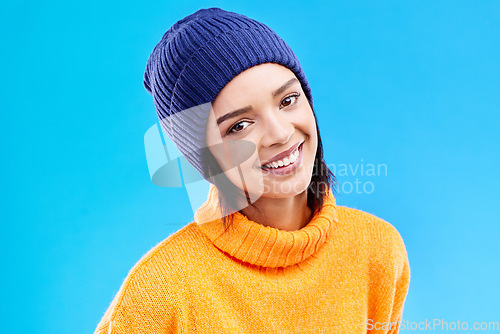 Image of Portrait of happy woman in winter fashion with smile, beanie and jersey isolated on blue background. Style, happiness and face of gen z girl in studio with hat and warm clothing for cold weather.