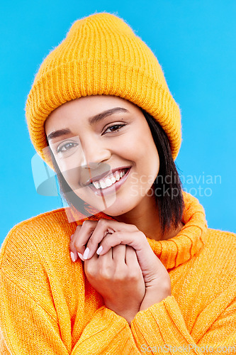 Image of Happiness, excited portrait and woman with mockup in studio ready for cold weather with winter hat. Isolated, blue background and mock up with a happy young and gen z person with a smile and beanie