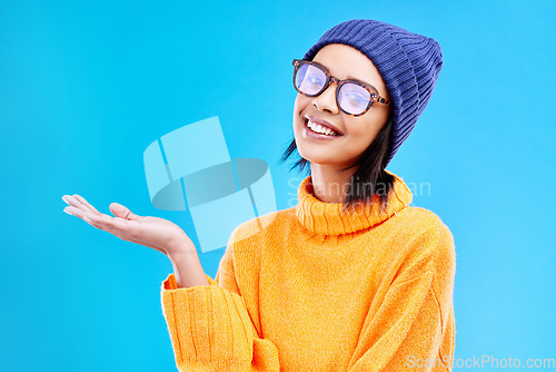 Image of Woman palm, smile and portrait in a studio with promotion and announcement. Excited, isolated and blue background with mockup of a gen z girl and cool young female show marketing with happiness