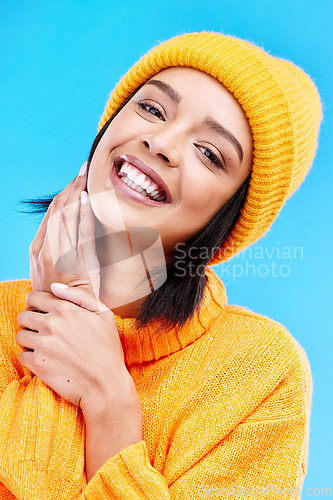 Image of Happiness portrait, excited and woman with youth in studio ready for cold weather with winter hat. Isolated, blue background and positivity with a young and gen z person with a smile, beanie and joy