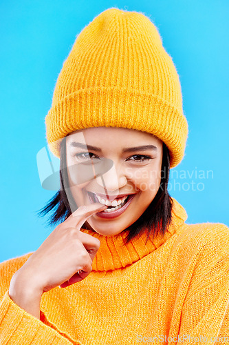 Image of Portrait of woman in winter fashion with happy face, beanie and smile isolated on blue background. Style, happiness and gen z girl in studio backdrop, mockup and flirt, warm clothing for cold weather