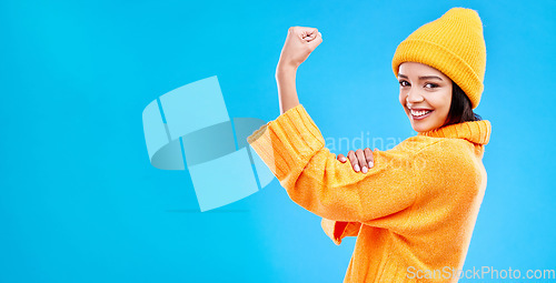 Image of Strong, mockup and a portrait of a woman with muscle isolated on a blue background in a studio. Smile, style and a girl showing fashion for empowerment and confidence on a backdrop with space