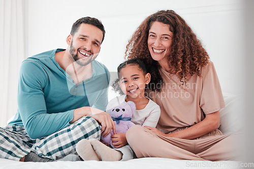 Image of Portrait, love and family in bed, smile and bonding for quality time, comfortable and relax. Face, happy parents and mother with father, female child and daughter in bedroom, interracial or happiness