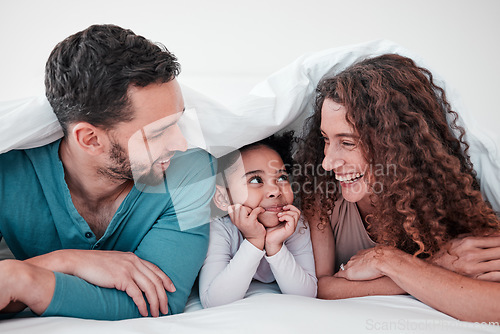 Image of Family, parents are happy with child in bed and relax under blanket in bedroom with smile, love and care. Spending time together, bonding and happiness, man and woman with young girl at home