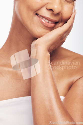 Image of Hand, mouth and skin with a mature woman in studio for beauty, anti aging treatment or cosmetics. Skincare, facial and wellness with a senior female touching her smooth face for hydration closeup