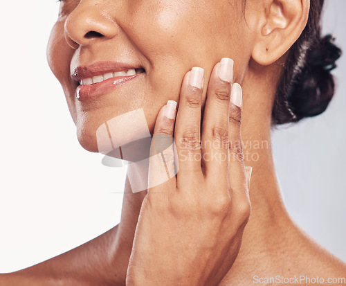 Image of Hand, mouth and facial with a mature woman in studio for skincare, anti aging treatment or cosmetics. Beauty, skin and wellness with a senior female moisturizing her face for hydration closeup