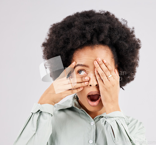 Image of Shock, scared and a black woman looking through hands isolated on a white background in a studio. Wow, scary and an African girl covering eyes with a hand for a horror, bad surprise or frightened