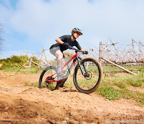 Image of Bicycle fitness, countryside road and woman on a bike with speed for sports race on cycling path. Adventure, biker exercise and fast athlete doing training in nature on a trail for cardio and workout