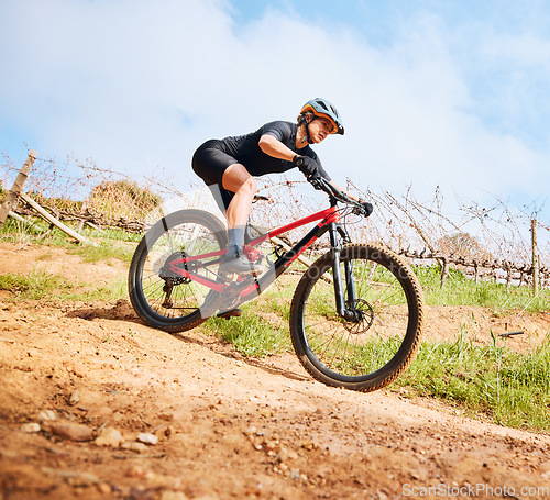 Image of Bicycle, hill ride and woman outdoor on a bike with speed for sports race on a gravel road. Fitness, exercise and fast athlete doing sport training in nature on a park trail for cardio and workout