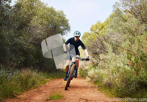 Image of Race, fitness and cycling with woman on dirt path in nature for workout, training and competition. Strong, cardio and exercise with female cyclist riding on mountain bike for adventure and journey