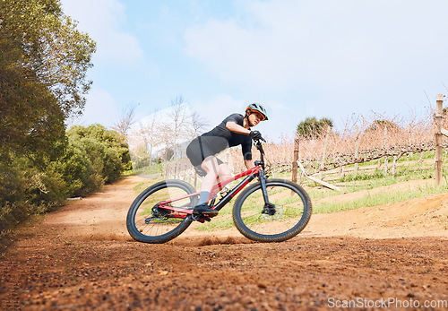 Image of Bicycle, ride outdoor and fitness woman on a bike with speed for sports race on a nature dirt road. Exercise, fast and athlete doing sport training on countryside trail for cardio and cycling workout