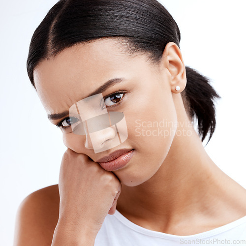 Image of Portrait, unhappy and frustrated with a woman in studio isolated on a white background looking moody. Face, frown and negative with a young woman looking confused, angry or bored while alone indoor