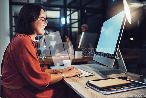 Image of Night, business and woman typing, smile and focus on data analysis, email and project deadline. Female employee, creative and worker with a computer, screen and working late for digital planning