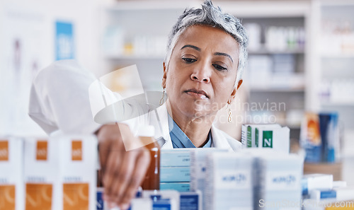 Image of Pharmacist woman, shelf and packing box for stock, inventory and organized store for healthcare. Pharmacy, senior business owner and medicine with focus for pills, customer experience and wellness