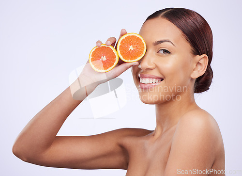 Image of Skincare, orange and woman portrait in studio for vitamin c, treatment and cosmetics on purple background. Face, fruit and girl model relax with diy facial, organic or skin detox with citrus cleaning