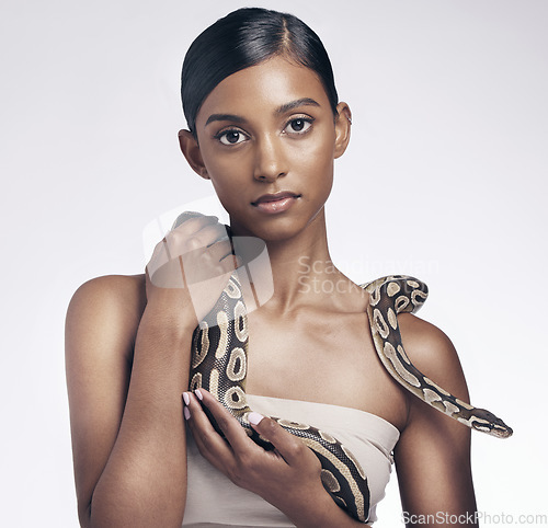 Image of Beauty, portrait and woman in studio with snake on neck for art aesthetic with exotic zoo animal on white background. Face, skin and creative style, asian fashion model holding dangerous pet python