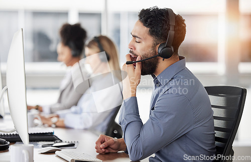 Image of Tired, yawn and man call center agent doing an online consultation on a computer in the office. Burnout, customer service and bored male telemarketing consultant working on crm strategy in workplace.