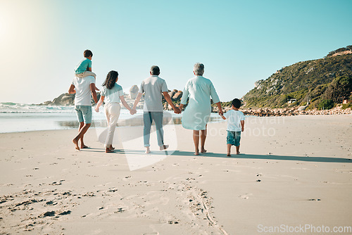 Image of Family, walking and holding hands outdoor on a beach with children, parents and grandparents together. Men, women and boy kids walk at sea with love, care and quality time for summer travel vacation