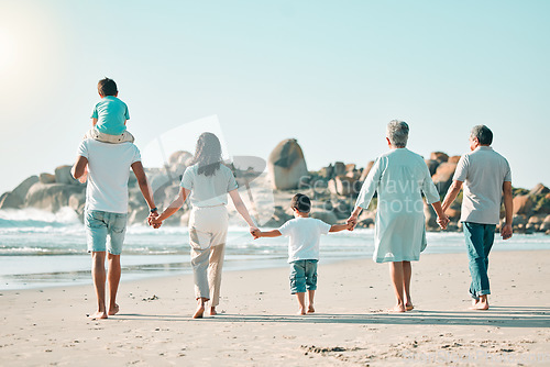 Image of Holding hands, beach and rear view of big family walking at the sea, fun and travel on blue sky background. Behind, love and children with parents and grandparents on an ocean walk traveling in Miami