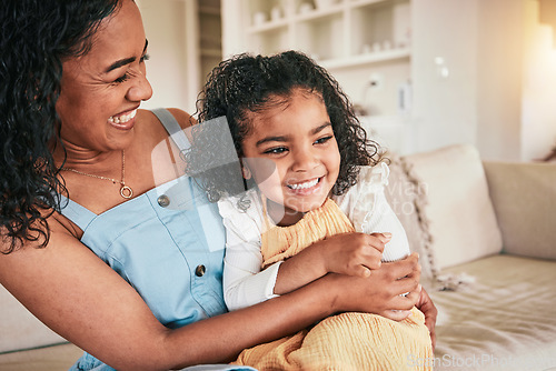 Image of Happy, hug and laughing with mother and daughter on sofa for bonding, affectionate and love. Support, cuddle and smile with woman and young girl in living room at home for relax, care and embrace