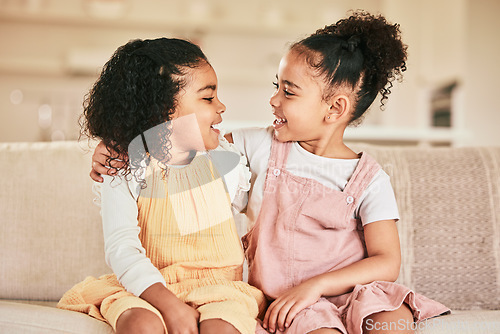 Image of Happy, children and sisters hugging on a sofa while bonding in the living room of their home. Happiness, friendship and girl kids embracing while talking and spending quality time together in a house