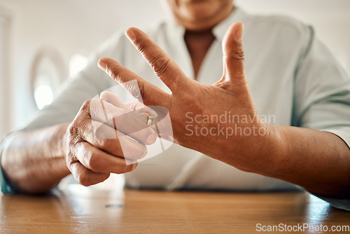 Image of Divorce, ring and hand of old woman at home for separation, breakup and conflict. Marriage problem, relationship issues and finish with wife finger and decision for change, disagree and leave