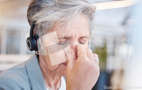 Image of Senior woman, headache and tired at call center with stress from consulting, telemarketing or crm job. Elderly female, tech support consultant and exhausted in office with burnout, fatigue or anxiety