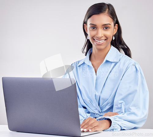 Image of Laptop, studio and portrait of Indian woman with smile working online for research, internet and website. Technology, communication and female worker on computer typing email on white background