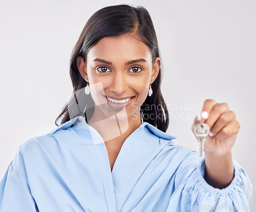 Image of Happy, homeowner and a portrait of a woman with keys isolated on a white background in a studio. Giving, smile and a girl holding a key to a house, apartment or property for real estate on a backdrop