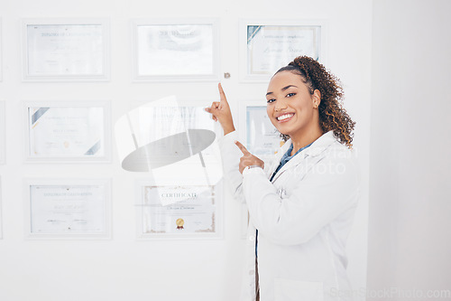Image of Certificate, medical and pointing with portrait of woman for success, graduation and pride. Achievement, happy and smile with female and showing award wall for education, healthcare and pharmacy
